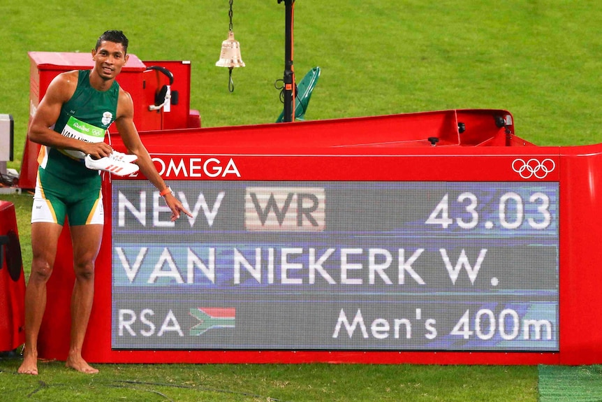 Wayde van Niekerk of South Africa poses next to his winning time at the Rio Olympics 400m final.