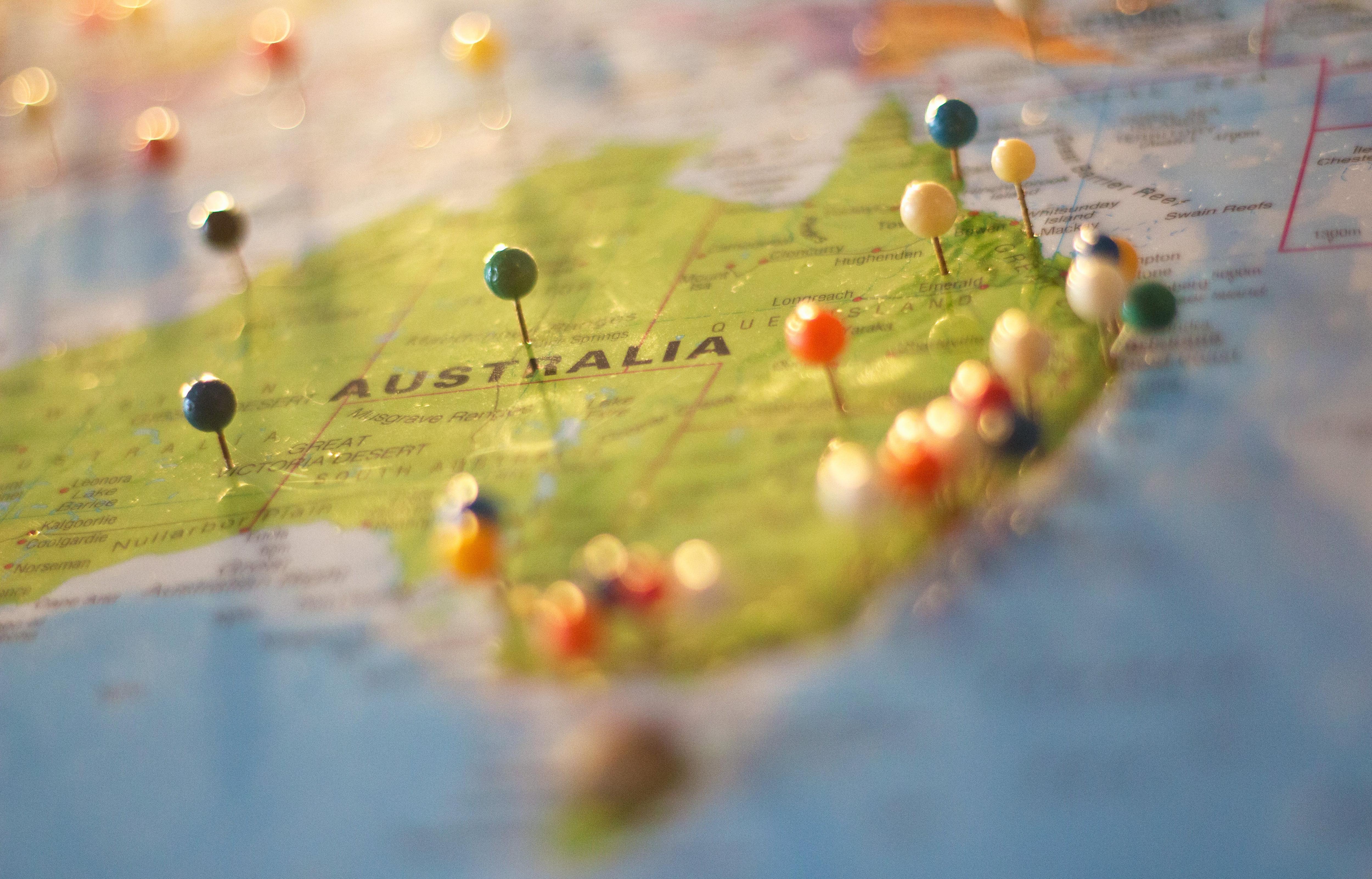 A generic undated stock photo showing a map of Australia with heaps of pins stuck in it.
