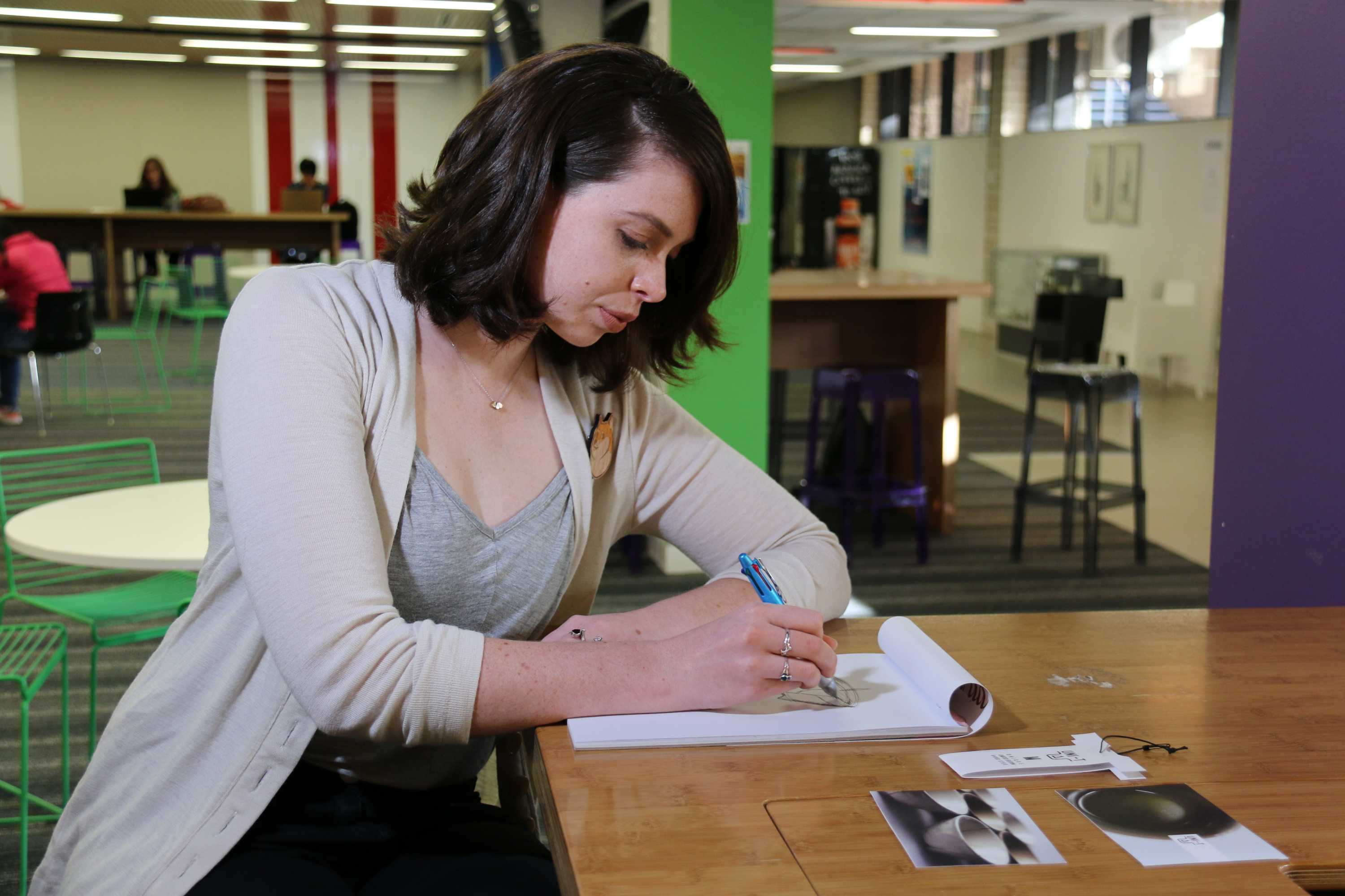 University of Canberra design student Alison Barracluff drawing in her sketch book.