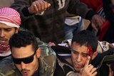 Libyan rebels protect an alleged member of Moamar Gaddafi's revolutionary committee.