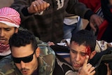 Libyan rebels protect an alleged member of Moamar Gaddafi's revolutionary committee.