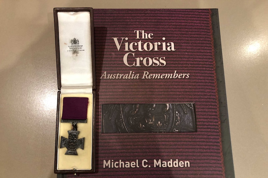 book on the victoria cross with a victoria cross medal sitting on it