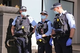Three police officers wearing masks on duty in Canberra.