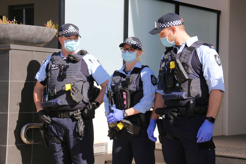 Three police officers wearing masks on duty in Canberra.