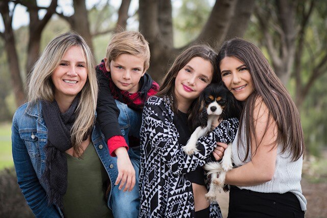 A mother with her son, two daughters and the family dog.
