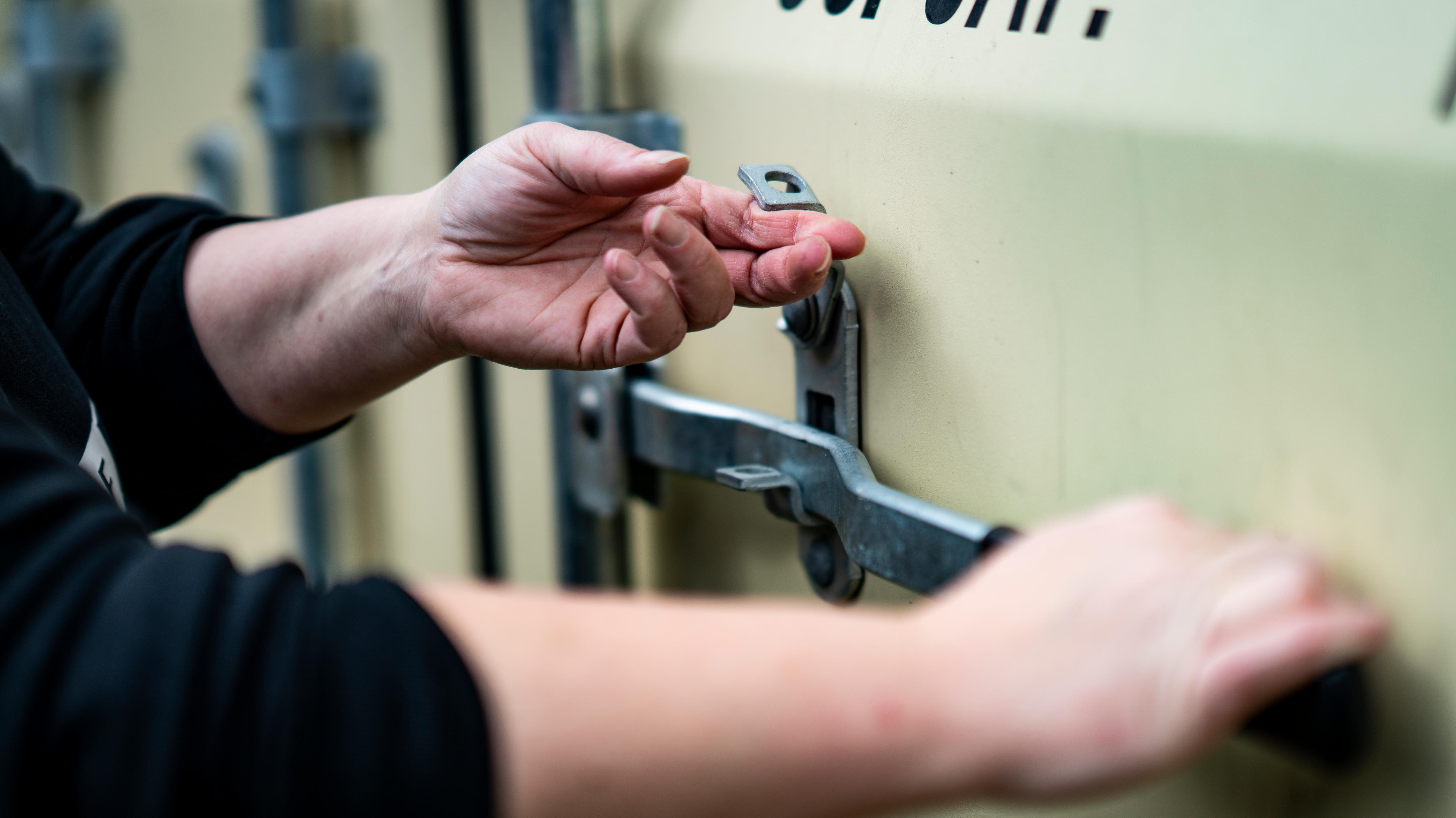 Hands opening a shipping container
