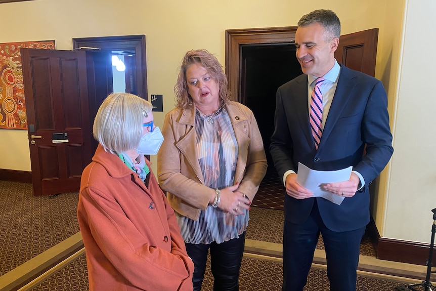 Lyndal Johnson, 71, with social services minister Nat Cook and the premier. 