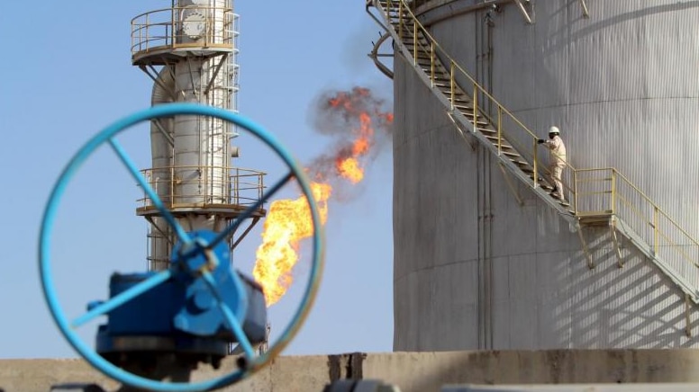 A worker climbs the stairs at an oil storage facility in Iraq.