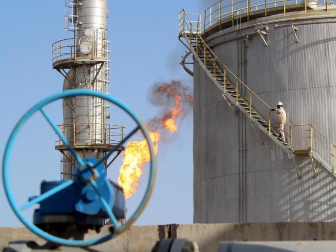 A work climbs the stairs at an oil storage facility in Iraq