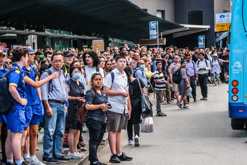 Hundreds of people waiting for a bus