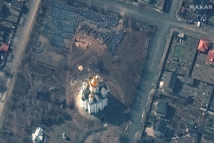 A satellite image of a large church surrounded by grass and a small trench.