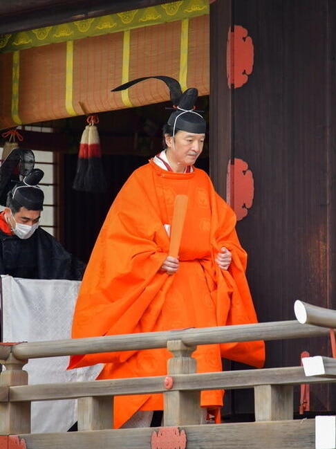 Japan's Crown Prince Akishino (in orange robe) attends a ritual ceremony.