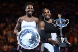 Serena (R) and Venus Williams show off their trophies after the Australian Open women's final.