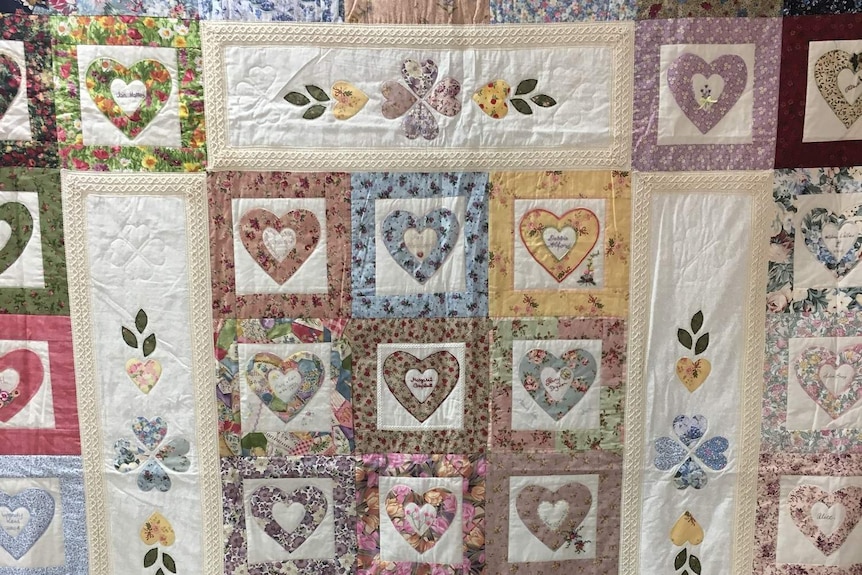 A quilt made of blocks with hearts and names
