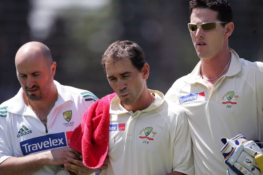 Justin Langer is helped off the cricket field by teammate Shaun Tait and physiotherapist Alex Conturi.
