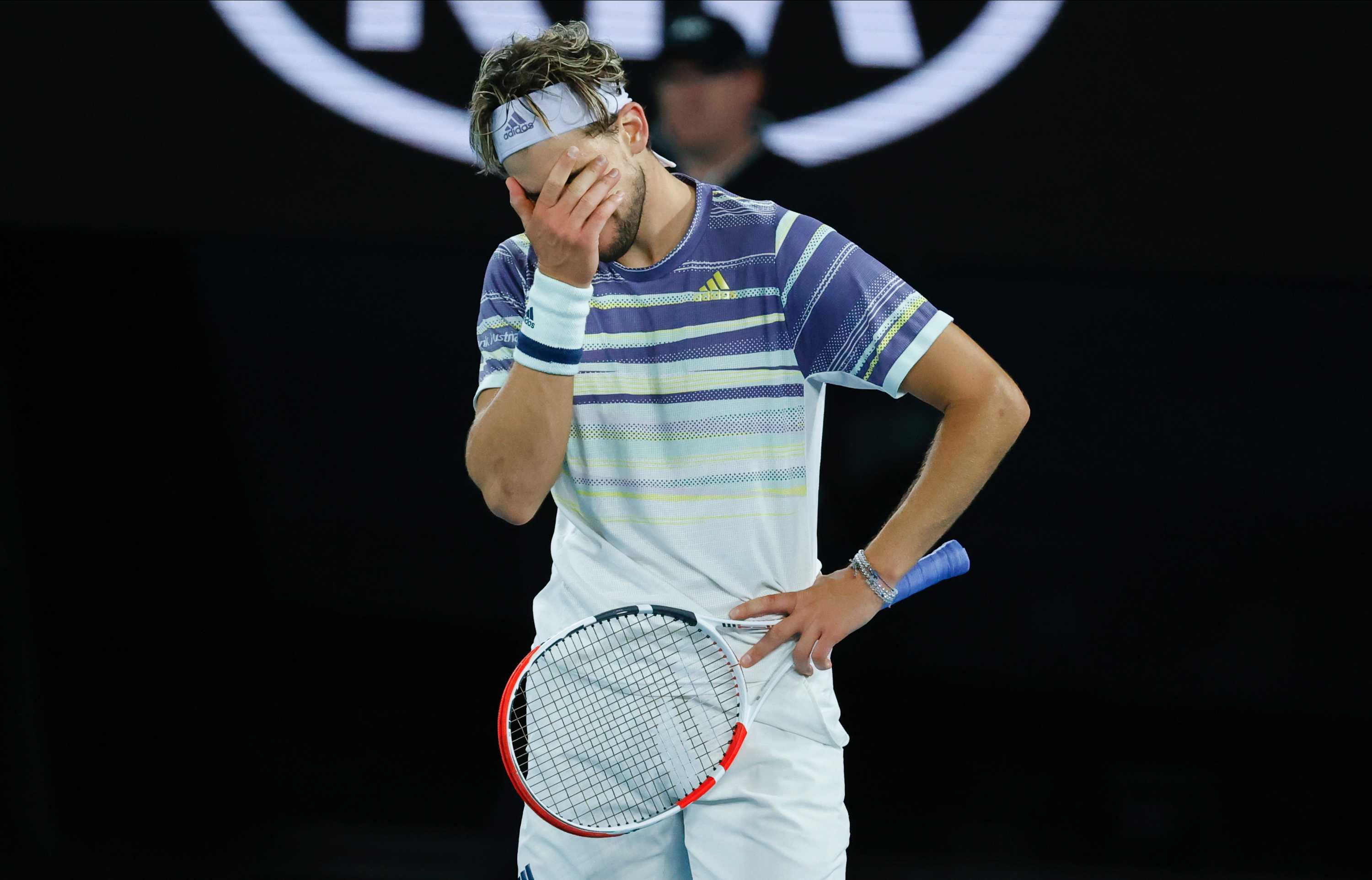 Dominic Thiem 在澳大利亚网球公开赛决赛对阵 Novak DJokovic 时用手捂着脸。
