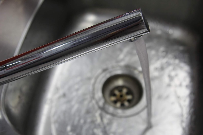 A photo of water running from a tap into a sink.