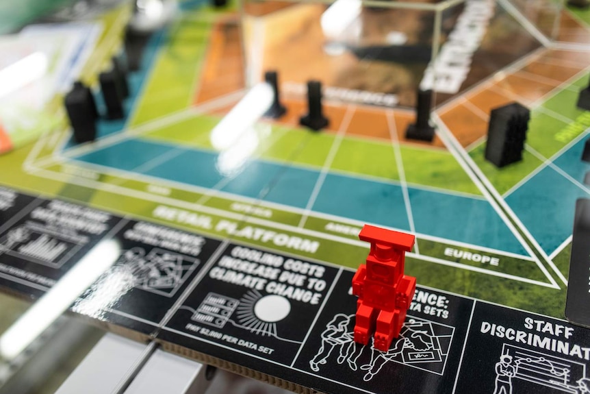 Close up of colourful boardgame mat with bright red piece front of frame.