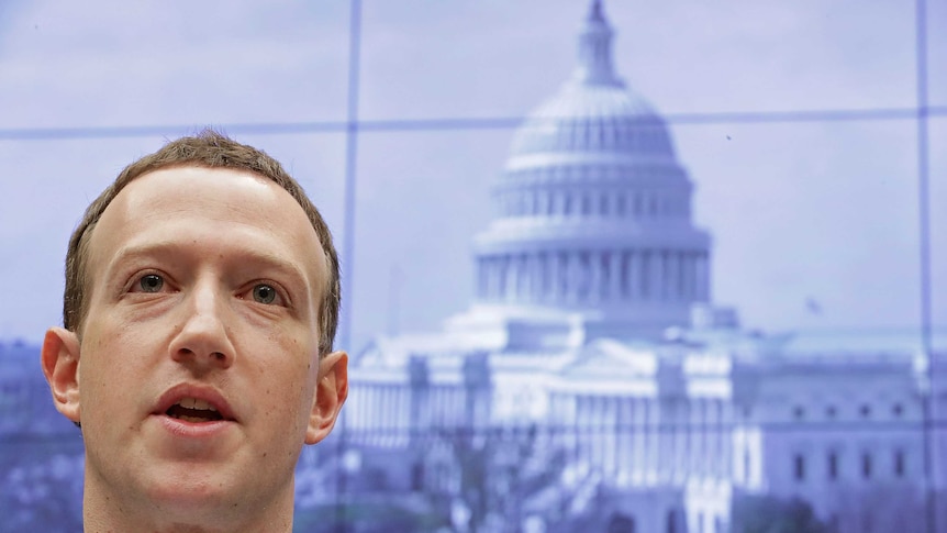 Facebook co-founder and CEO Mark Zuckerberg testifying in Washington DC. Behind him is a picture of Capitol Building.