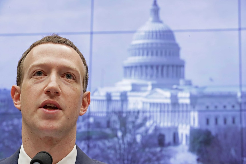 Facebook co-founder and CEO Mark Zuckerberg testifying in Washington DC. Behind him is a picture of Capitol Building.