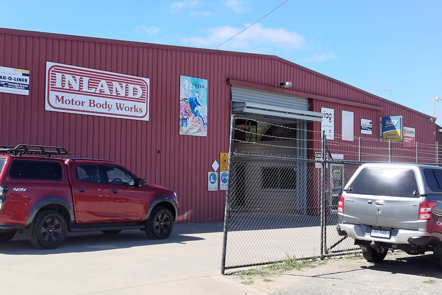 A red building with sign that says Inland Motor Body Works