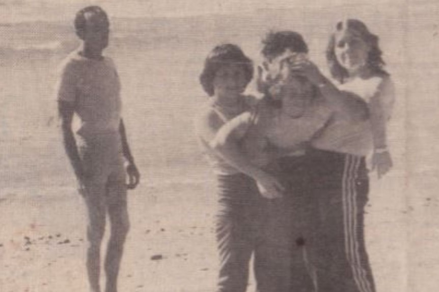 Three women demonstrate a rescue and resuscitation event, carrying another woman in rescue carry.