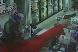 A gunman holds a petrol station attendant hostage (Supplied)