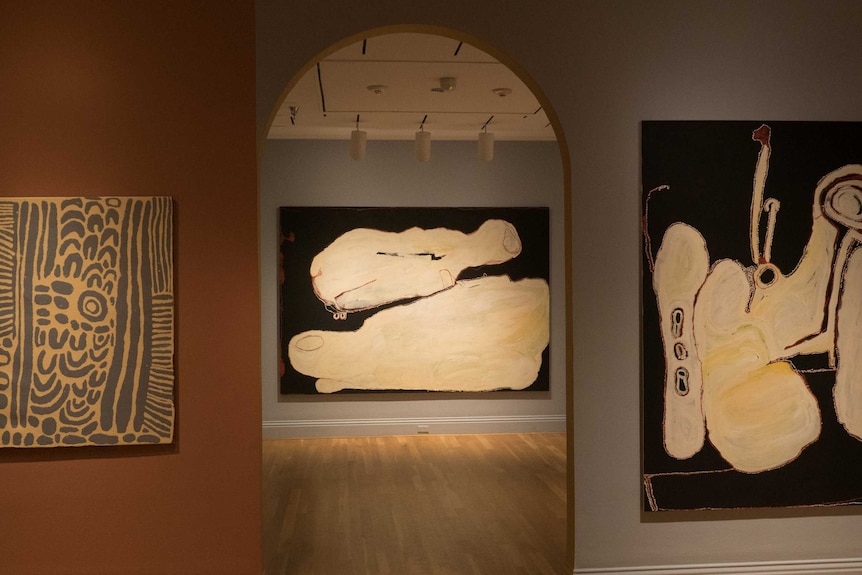 Three Indigenous artworks hang in a gallery