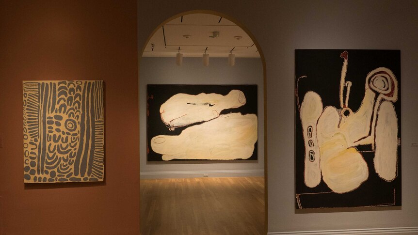 Three Indigenous artworks hang in a gallery