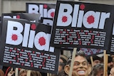 Demonstrators hold placards during a protest