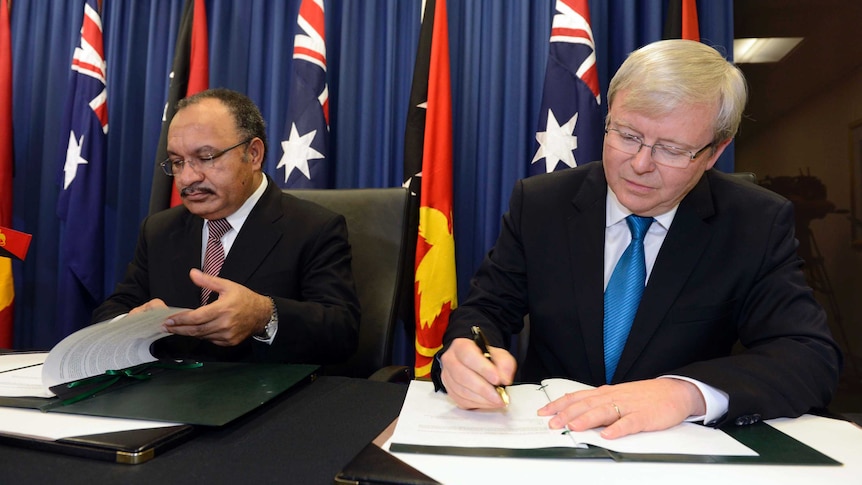 Kevin Rudd and Peter O'Neill sign the agreement.