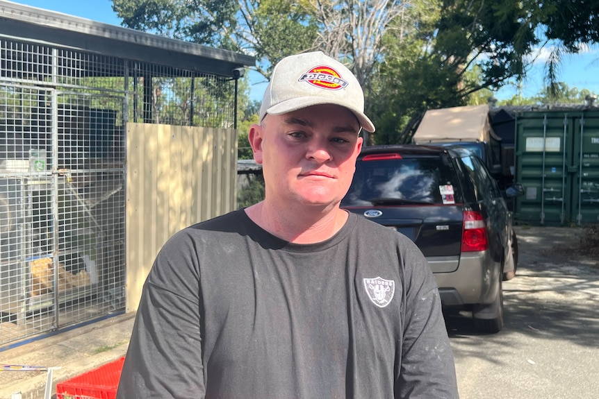 man in cap stands outside in queensland sun