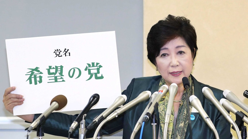 Tokyo Govenor Yuriko Koike holds the name of her Hope Party (in Japanese characters) during a press conference.