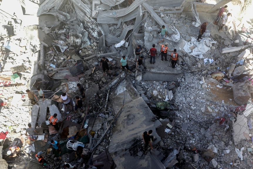 Palestinians look for survivors under the rubble of a destroyed building following an Israeli airstrike.