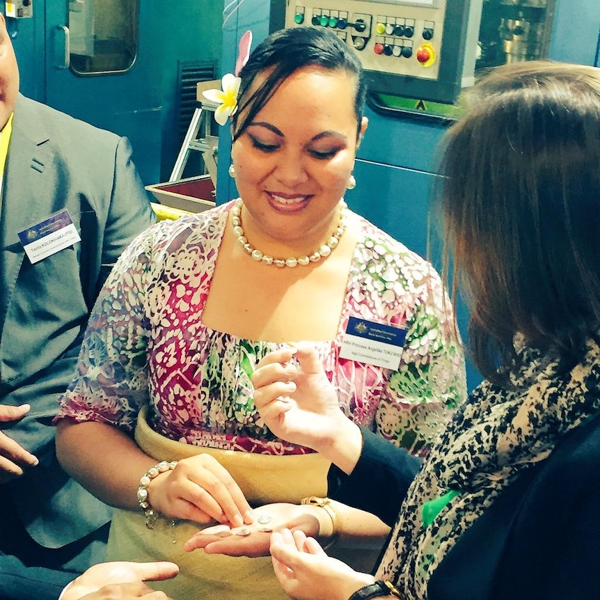 Tongan princess Angelika Tuku'aho holding coins.