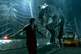 A t-rex chases after a man in a scene from the Jurassic Park movie.