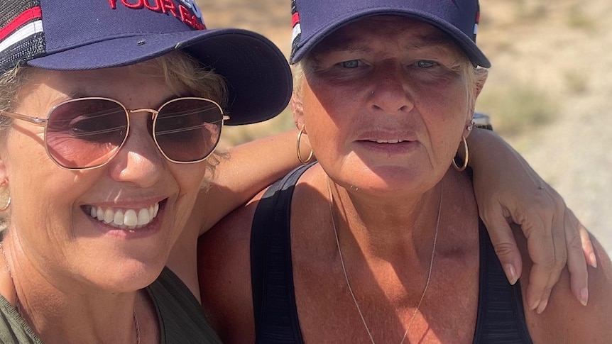 two women in a selfie, both wearing caps reading "we've got your back'.