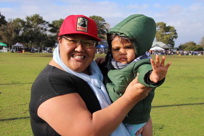 Tash Koyanasau and her daughter cheer on the Palmyra Rugby Union Club at Charles Court Reserve in Nedlands.