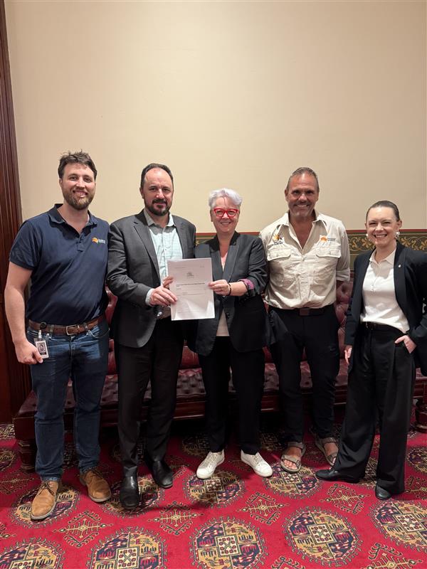 a group of people hold up a document