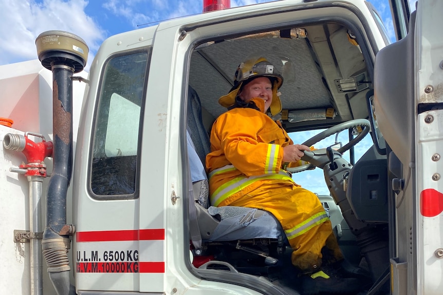 Woman in CFS uniform sitting high up in firetruck cabin.