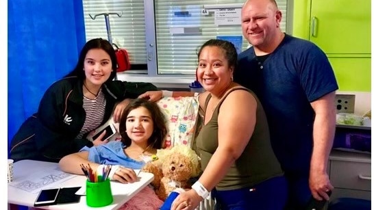 Jezzie in hospital with her family