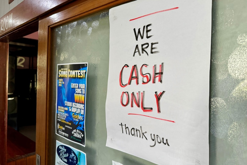 a paper cash only sign stuck onto a glass door