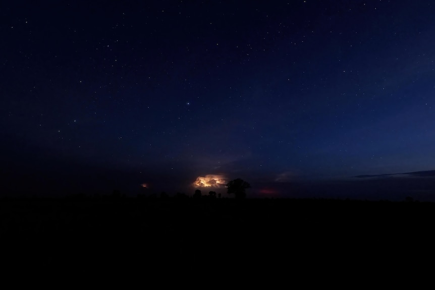 A lightning shot can be seen the in the distance of a gloaming night sky