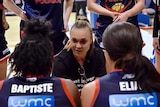 Tully Bevilaqua crouches in the centre of a huddle and gives a speech to her basketball team.