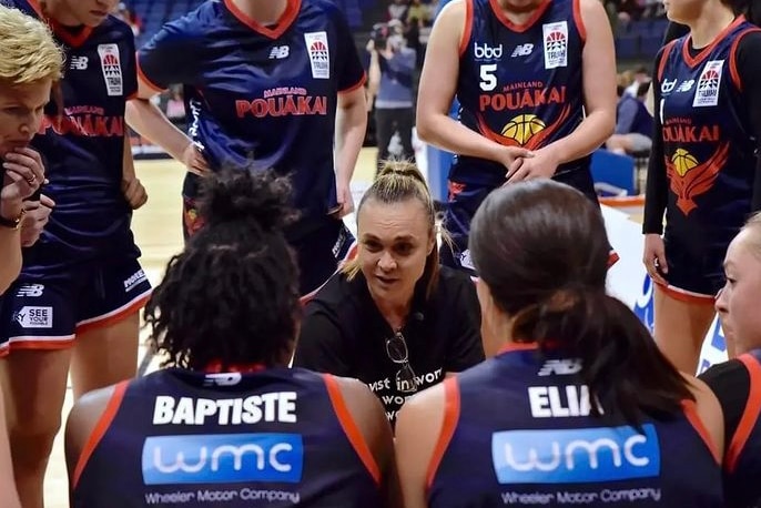Tully Bevilaqua crouches in the centre of a huddle and gives a speech to her basketball team.