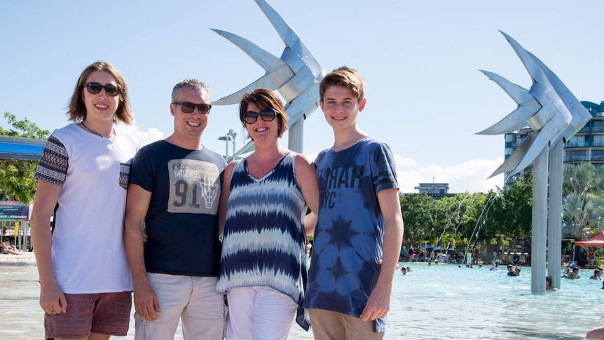 The Merriman family, Luke, Debbie, Andy and Alex stand in front of the iconic fish water feature at the Cairns Esplanade Lagoon.