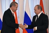 Putin and Erdogan shake hands.