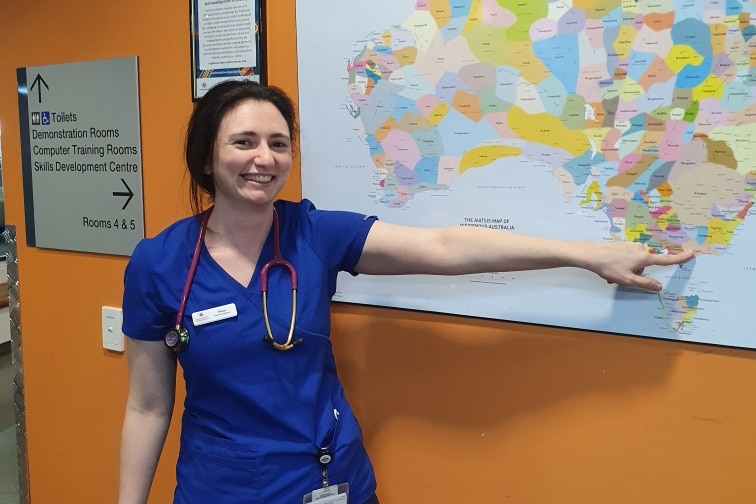 A person in a hospital pointing to a map