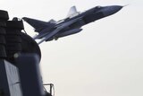 A Russian Sukhoi Su-24 flying close to a US destroyer.