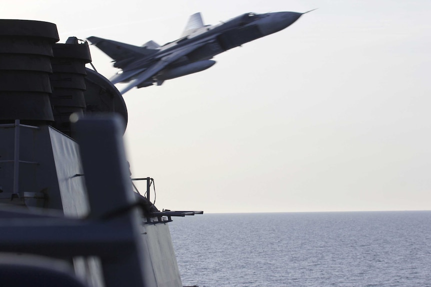 A Russian Sukhoi Su-24 flying close to a US destroyer.